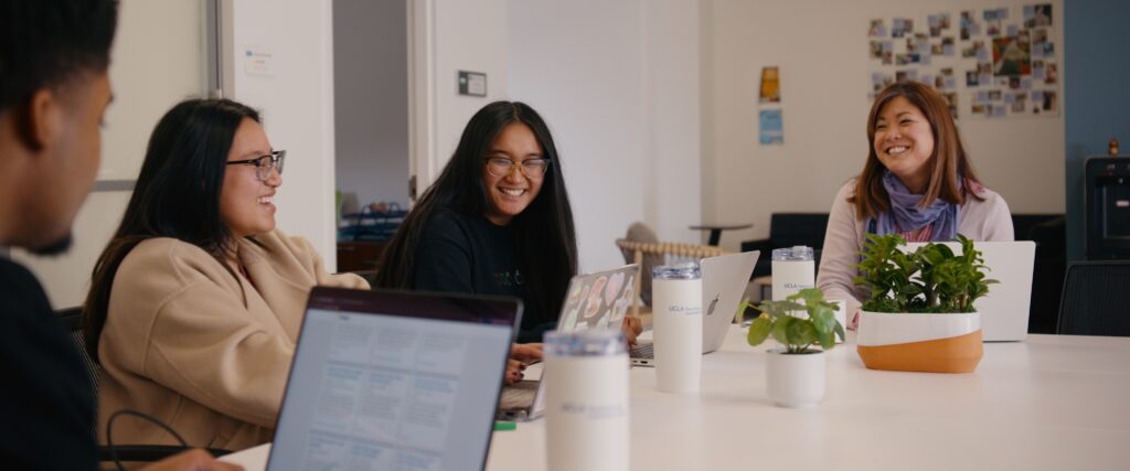 TLC Staff sit around a table and talk