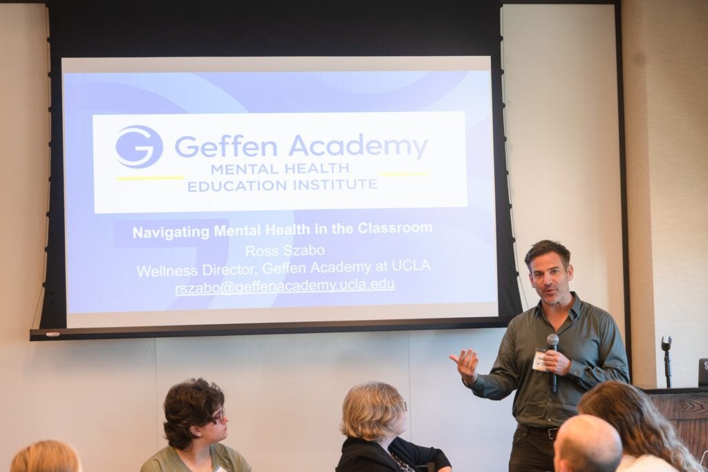 Photo of Ross Szabo in front of a projector during his training