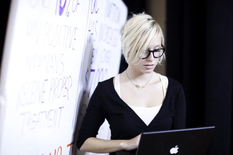 Photo of student with a laptop near a whiteboard