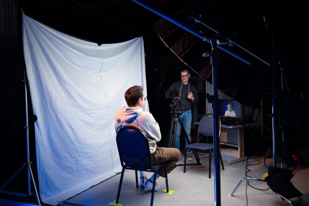 Photo of videographer and subject in the studio