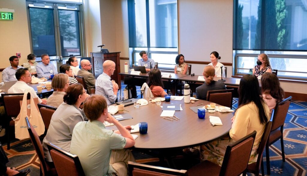 Attendees watch a panel discussion from experienced faculty at the Institute. 