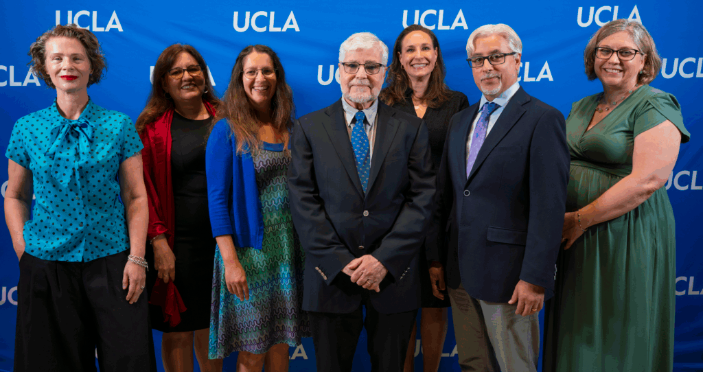 Tamar Christensen, Diana Márquez-Garbán, Shanna Shaked, Vice Chancellor Michael Levine, Bonnie Goff, Rafael Romero, and Vice Provost Erin Sanders O'Leary against a blue UCLA background.