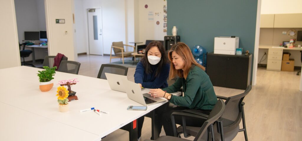 TLC staff seated around a laptop on a desk