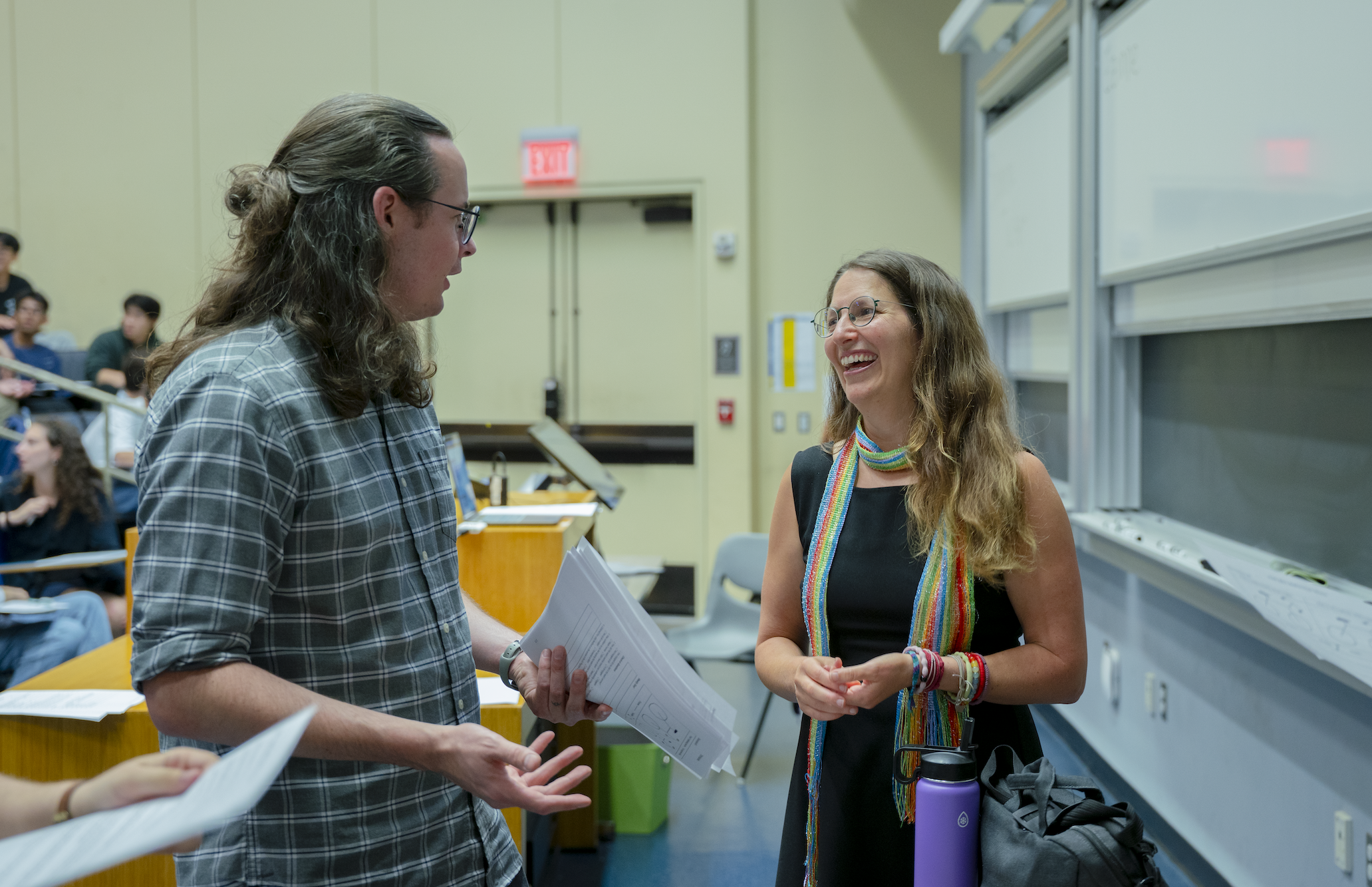 Educational Innovation Grant-winning instructor with a learning assistant speaking together during class.
