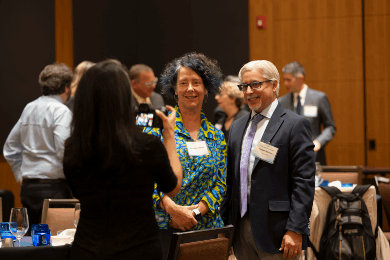Photo of award recipient standing with a guest getting their photo taken.