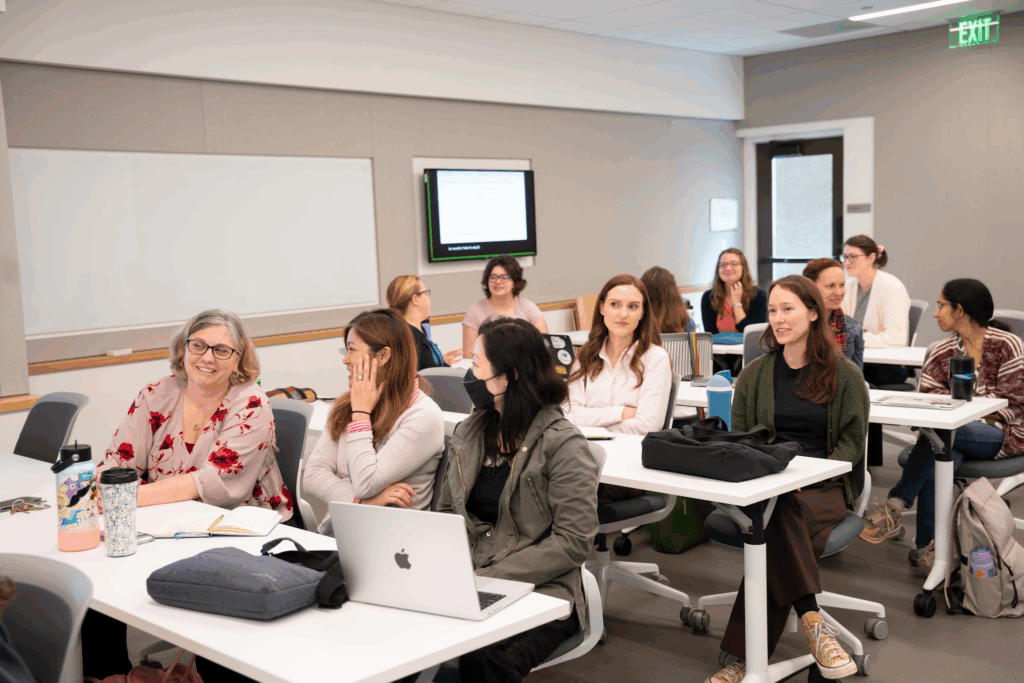 Scholarly Teaching Seminar attendees sit at tables and talk to one another