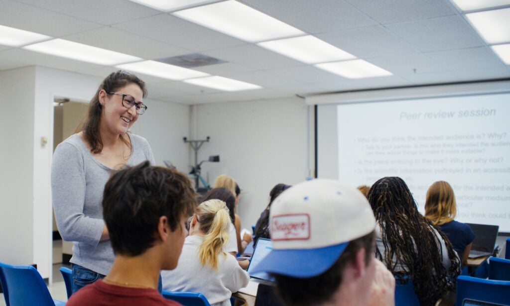 Graduate instructor speaks to students seated in a classroom