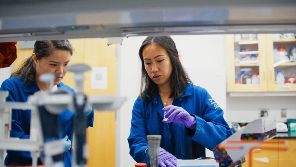 Teaching Assistant and student in a lab performing tests with equipment