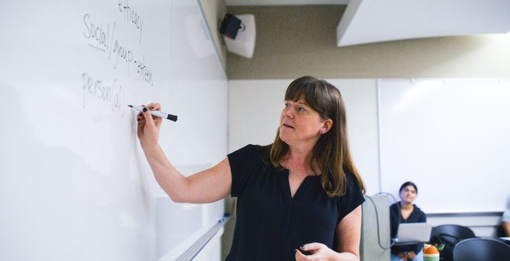 Instructor writing on a whiteboard