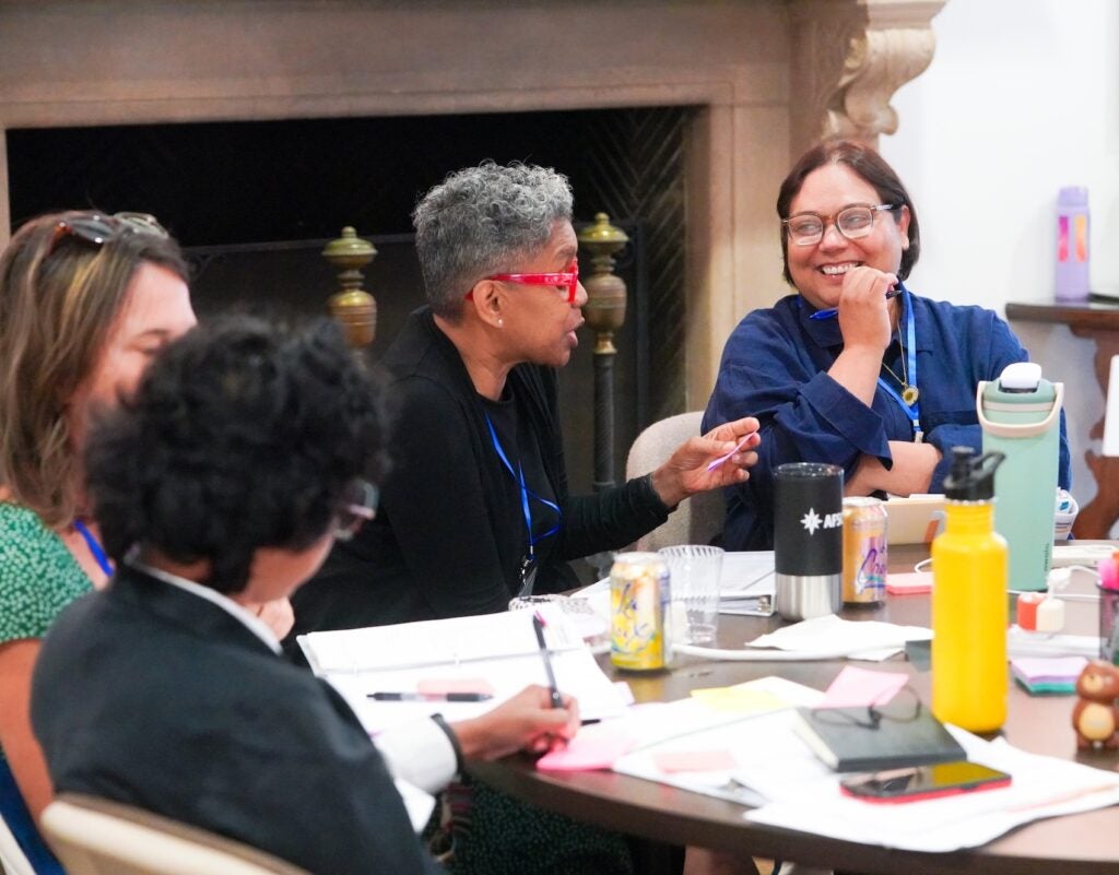 Instructors seated at a round table in conversation