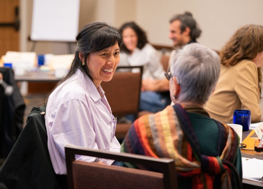 Instructors in conversation with one another at a table