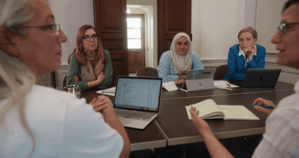 Holistic Evaluation of Teaching Participants working at a table