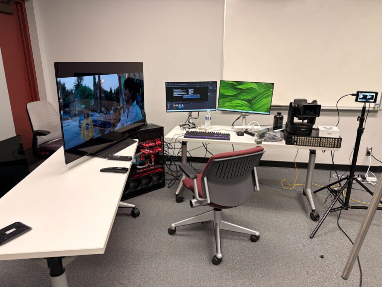 Immersive media production studio with computer monitors showing effects of green screen display.