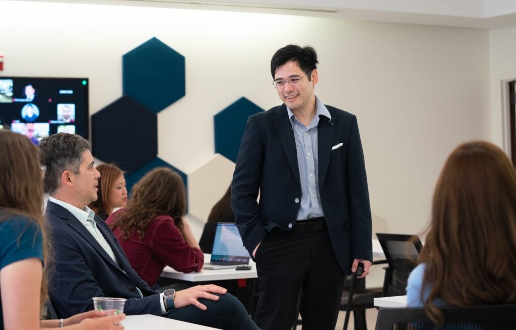 Andrew Estrada Phuong stands in a classroom talking to participants at the scholarly teaching seminar.