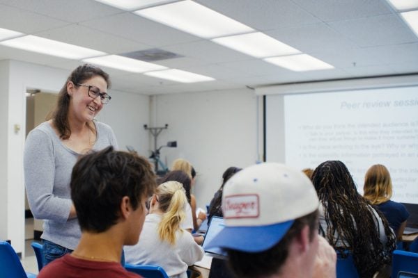 Graduate instructor speaks to students seated in a classroom