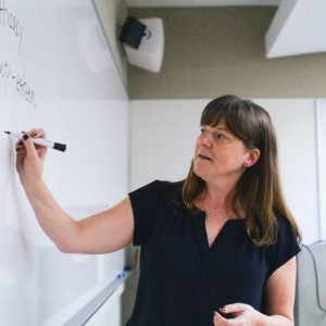 Instructor writing on a whiteboard