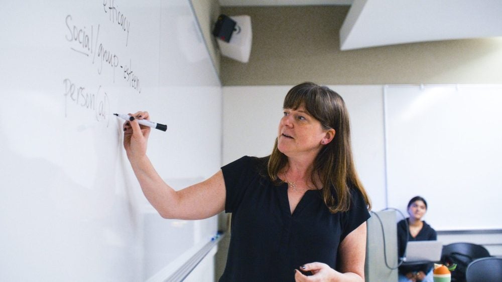 Instructor writing on a whiteboard