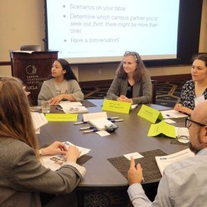 Photo of instructors gathered around a table