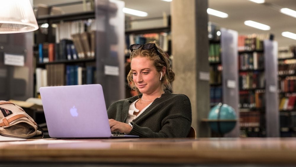 Photo of a student on a laptop in Young Research Library