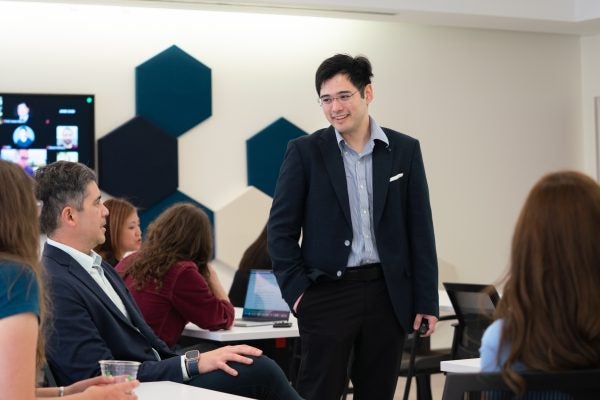 Andrew Estrada Phuong stands in a classroom talking to participants at the scholarly teaching seminar.