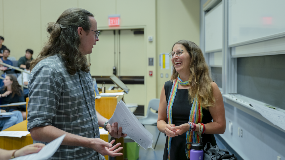 Instructor and a learning assistant speaking together during class.
