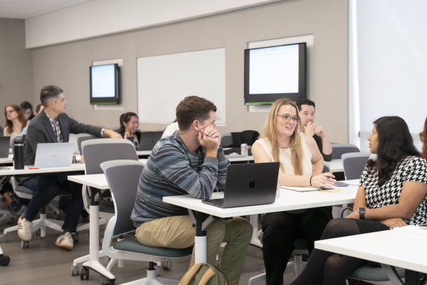 Teaching professors and staff in conversation at an event