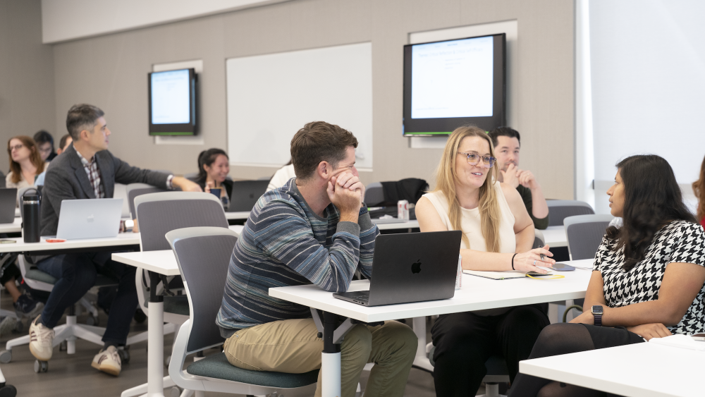 Teaching professors and staff in conversation at an event