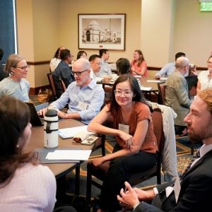 Attendees talking at a table during the New Instructor Teaching Institute.