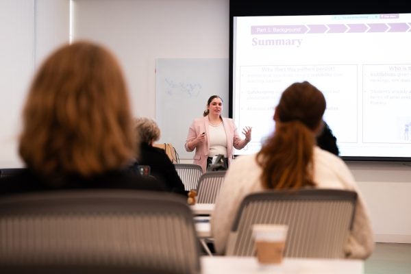 Instructor lectures in front of a whiteboard during a Scholarly Teaching Seminar