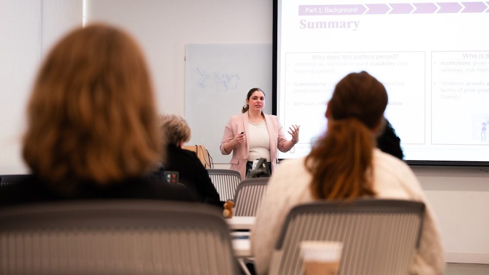 Instructor lectures in front of a whiteboard during a Scholarly Teaching Seminar