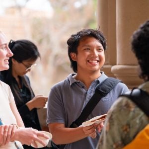 Graduate students smiling in a group at one another
