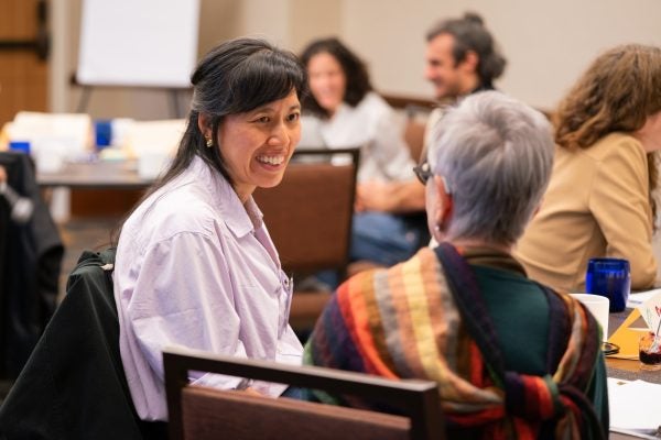 Instructors in conversation with one another at a table
