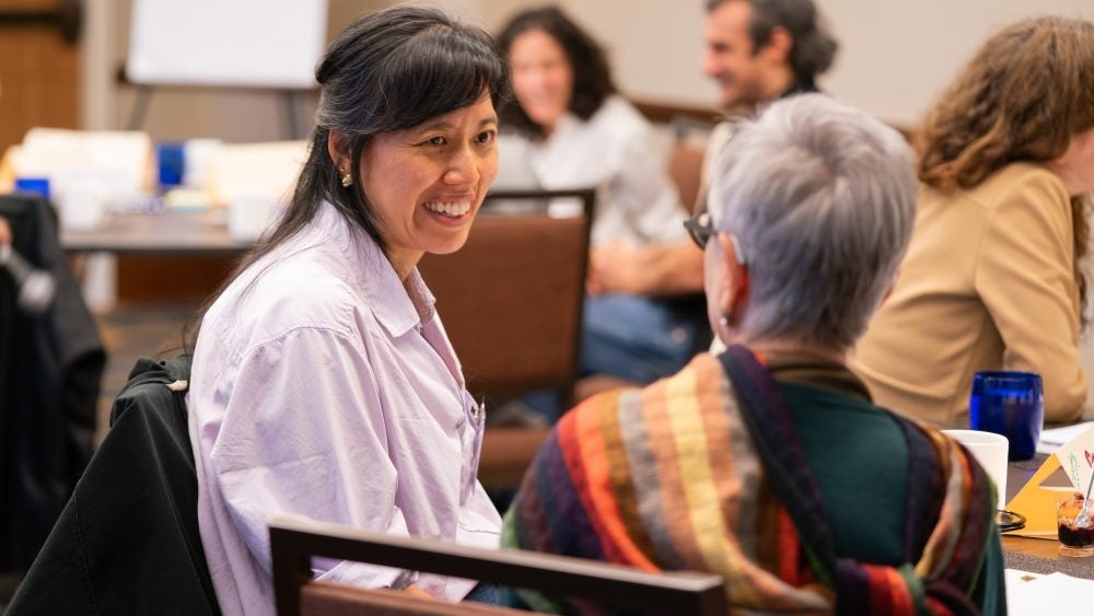 Instructors in conversation with one another at a table