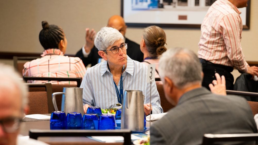 Attendee at the DaD Faculty Fellows Celebration seated in a conference room