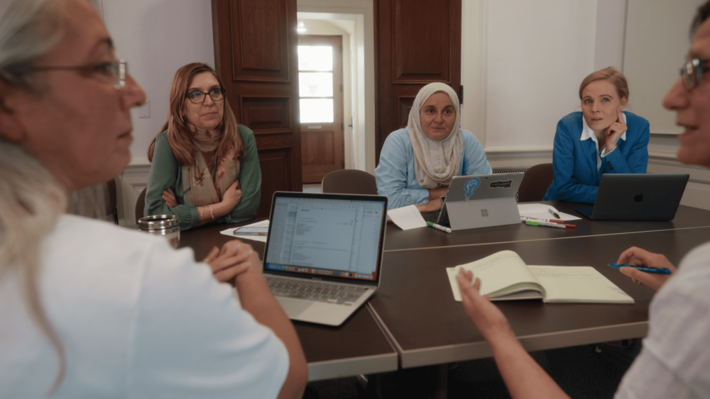 Holistic Evaluation of Teaching Participants working at a table