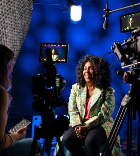 Distinguished Teaching Award winner in conversation with TLC staff member in front of a camera.