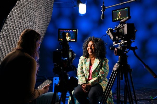 Distinguished Teaching Award winner in conversation with TLC staff member in front of a camera.
