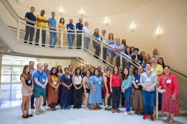 Participants and facilitators from the 2026 Summer Institute standing on a stairway.