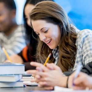 A multi-ethnic group of college students working together at school on an assignment.