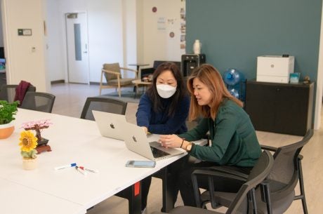TLC staff seated around a laptop on a desk
