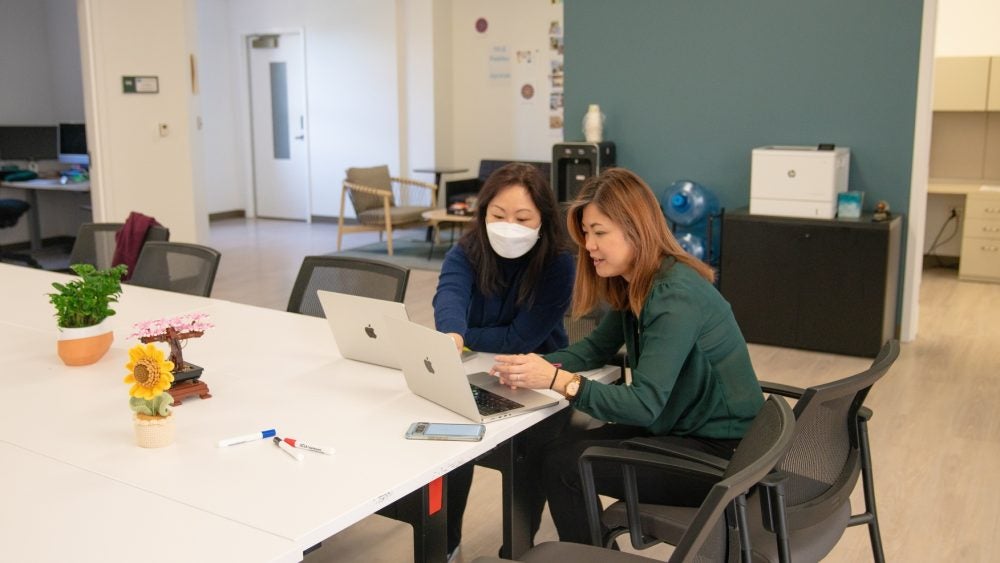 TLC staff seated around a laptop on a desk